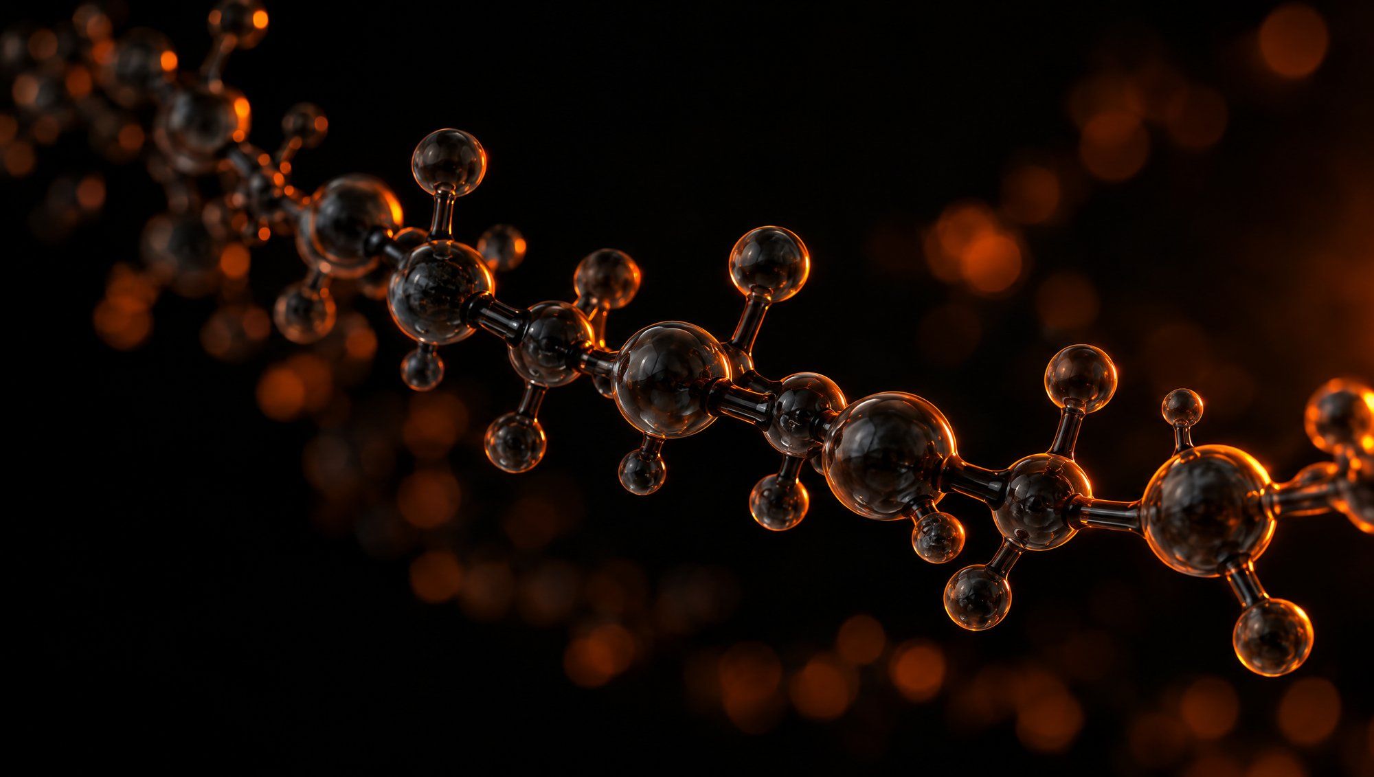 A curving chain of smoky glass spheres joined by dark glass rods, like a long molecule, floating against black with orange edge light and soft orange bokeh behind.